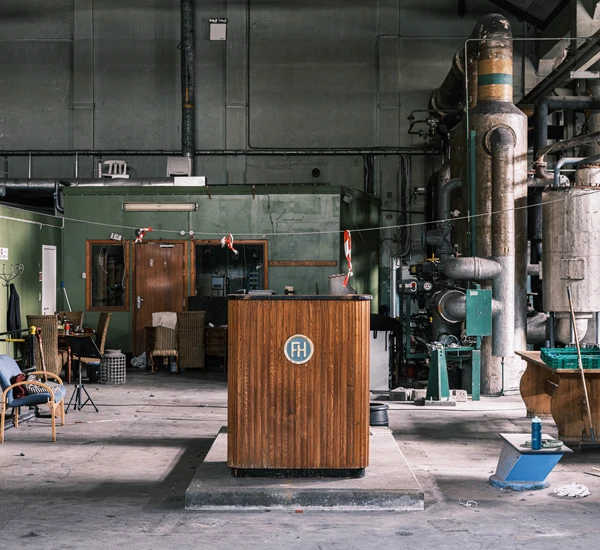 En talerstol står midt i et gammelt fabrikklokale. Foto.